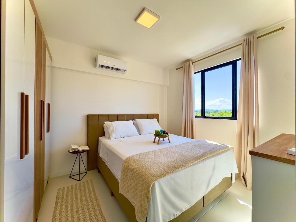 a bedroom with a bed and a large window at Apto 2 Quartos PISCINA Churrasqueira Wi-Fi Ar Condicionado Cozinha Complata Vaga de Garagem 400m PRAIA Ideal para Famílias ou Amigos Reserve Agora in Piçarras