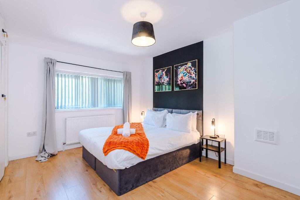 a bedroom with a large bed and a window at Spacious 4 Bed House in Birmingham City Centre, Ideal for long term with Free Parking in Birmingham