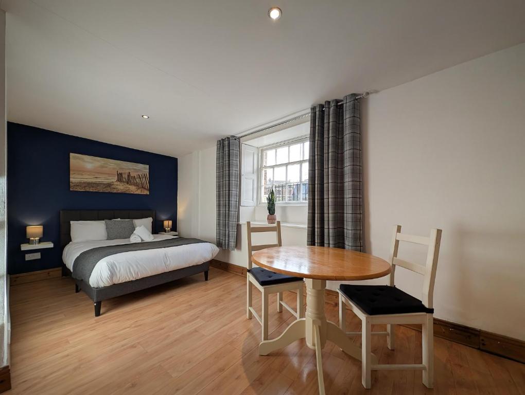 a bedroom with a bed and a table and a desk at Pass the Keys Charming 3-Bed Converted Basement Tynemouth in Tynemouth