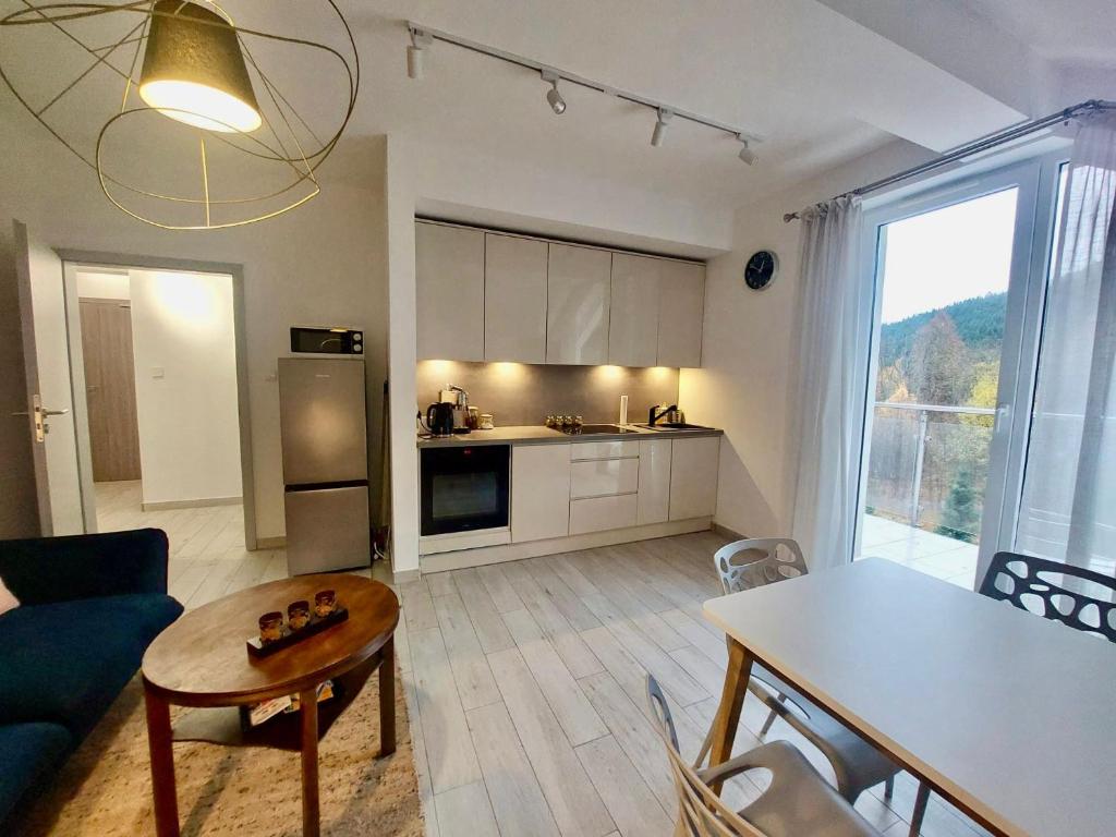 a living room with a table and a kitchen at Apartamenty Czarna Góra 31 in Sienna