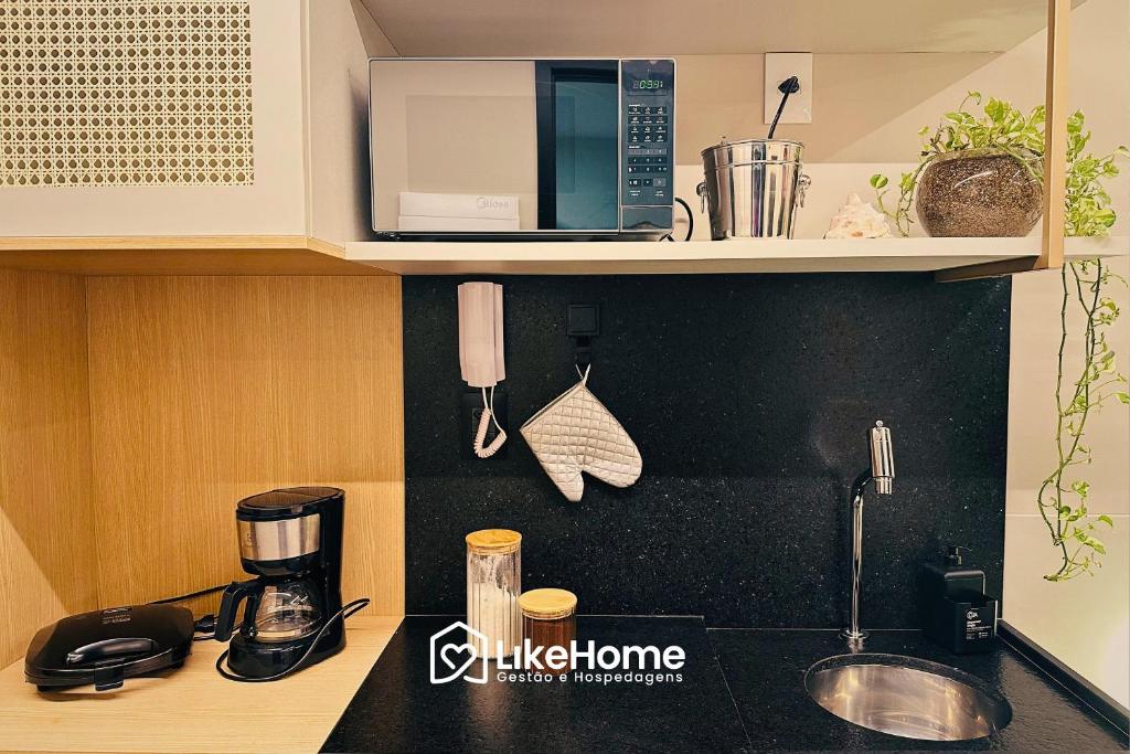 a kitchen counter with a coffee maker and a microwave at Move Tambaú ||| in Tambaú