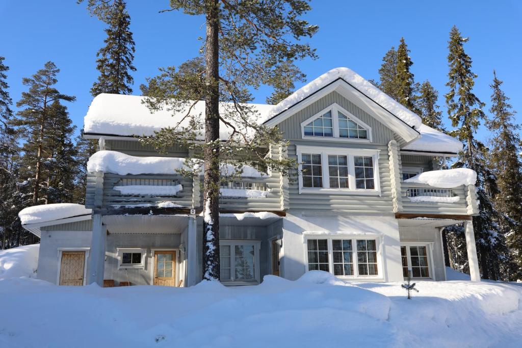 une maison blanche sous la neige dans l'établissement Luosto Villa D, à Luosto