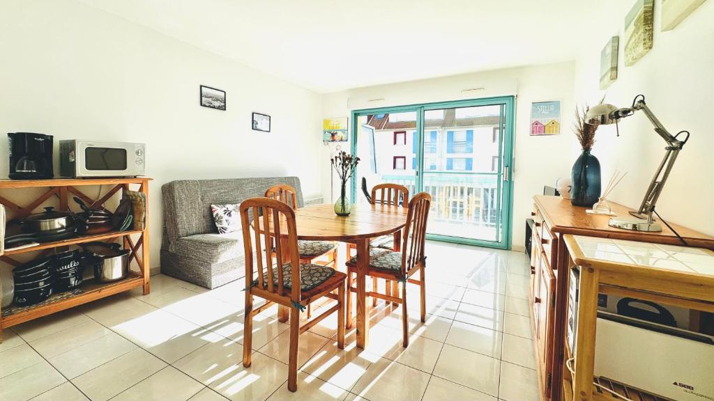 a living room with a table and chairs and a couch at L'air de Stella-Plage au coeur de la Station Balnéaire in Stella-Plage