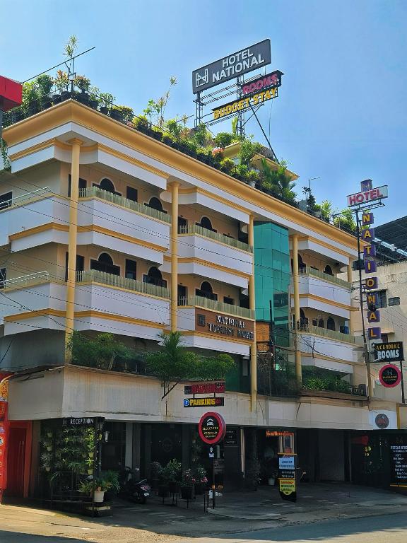 a large building with plants on the top of it at Hotel National Tourist Home in Trichūr