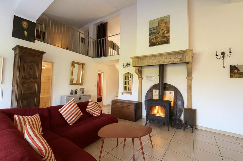 a living room with a couch and a fireplace at Le Clos de Vinzelle 12personnes Piscine in Vinzelles