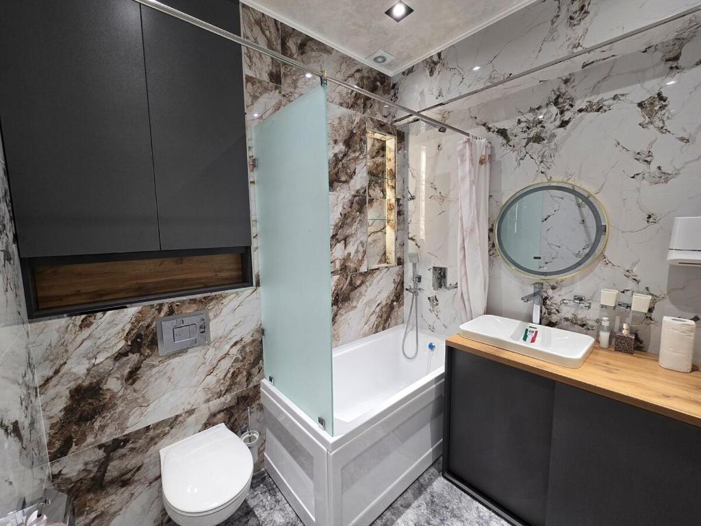 a bathroom with a toilet and a tub and a sink at Luxury apartment at 16th floor of Akay city in Tashkent near metro in Salor Bekati