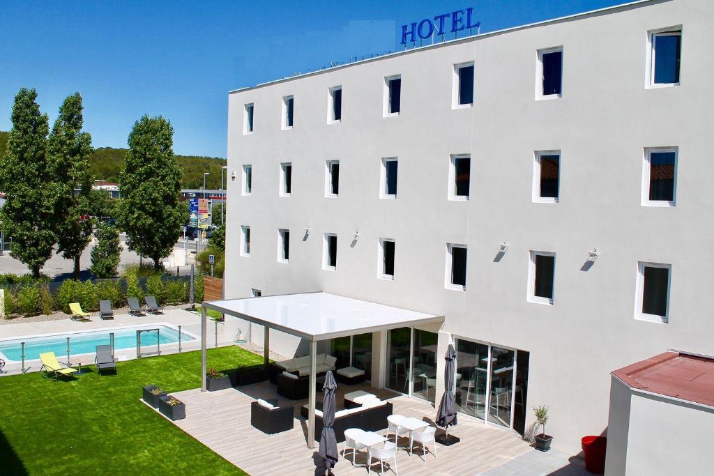 an external view of a hotel with a large white building at Brit Hotel Martigues Nord in Martigues