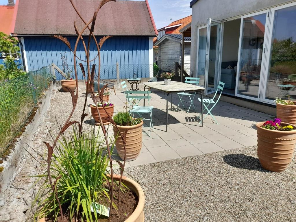 a patio with a table and chairs and potted plants at Studio apartment in Kivik in Kivik