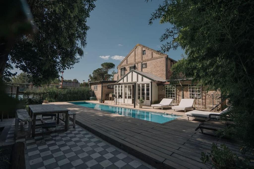 a swimming pool with a table and chairs next to a building at Casa de Lujo de Tenis con Pileta Padel y Gimnasio in Garín