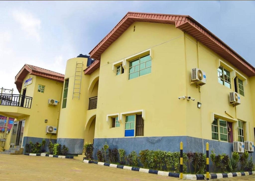a yellow building with windows and a roof at Gracefield hotel & suites in Eggan