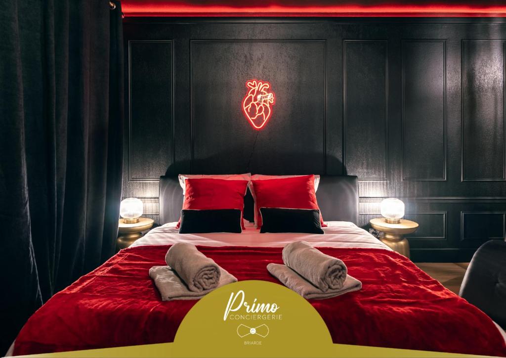 une chambre avec un grand lit avec des oreillers rouges dans l'établissement Love room - Le secret du marquis, à Provins