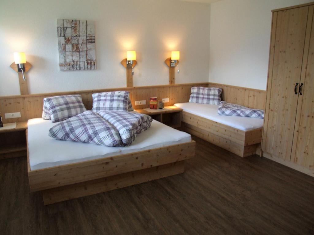 a room with two beds and a table and lights at Ferienwohnung Lehenhof in Ried im Zillertal