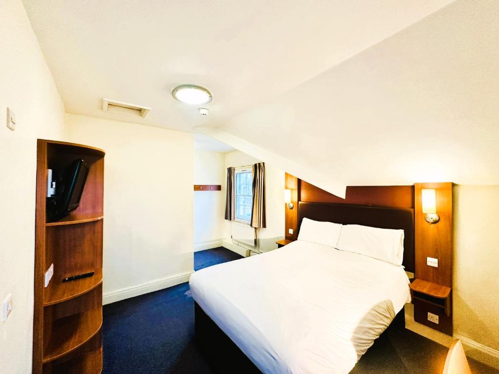 BroadheathにあるALTY Hotelのベッドとテレビがあるホテルの部屋