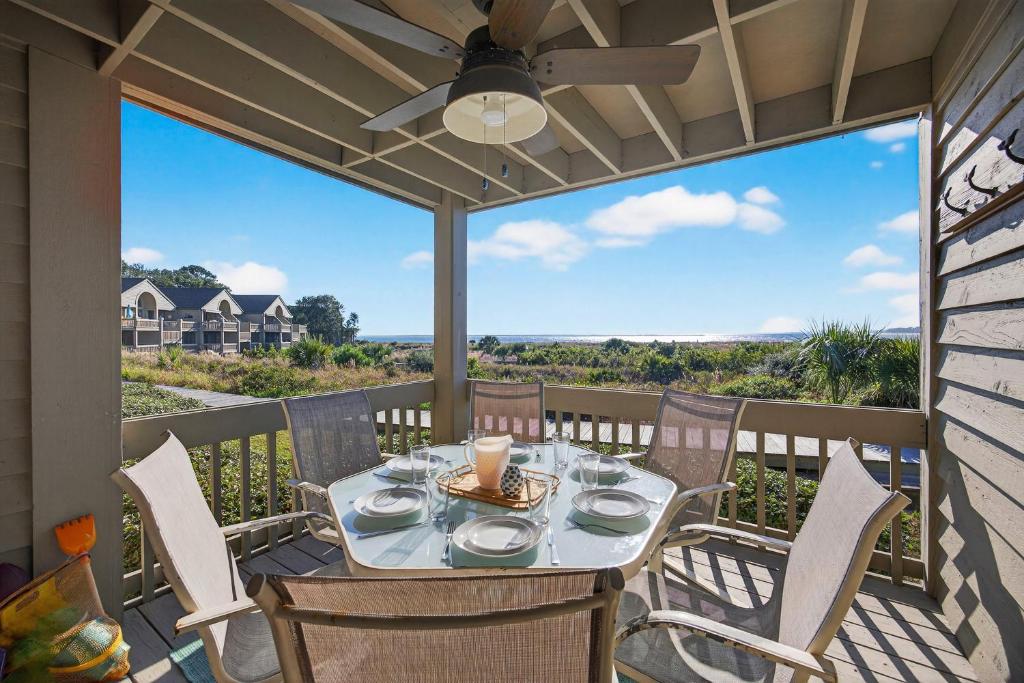 a patio with a table with chairs and a ceiling fan at PW1369: 1369 Pelican Watch in Seabrook Island