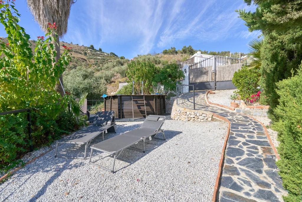 a group of benches sitting on a gravel patio at Cortijo A Navas in Frigiliana