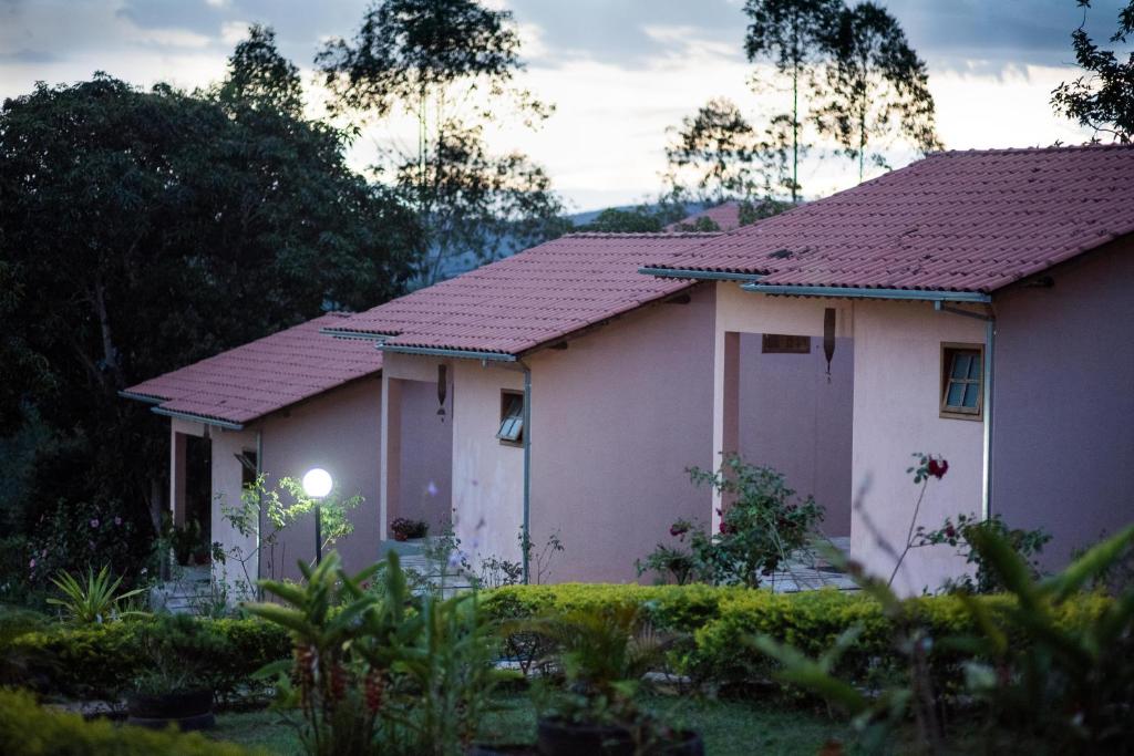 a white house with a red roof at Pousada Por-do-Sol in Conceição do Mato Dentro