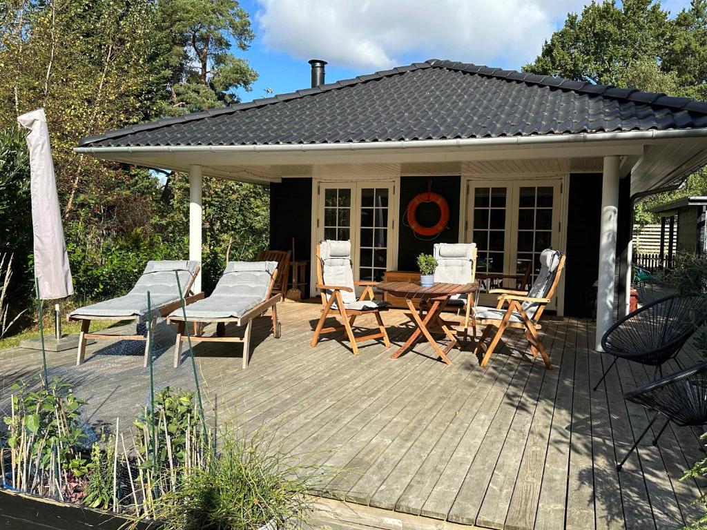 Un patio con una mesa y sillas en una terraza. en Perfect Base Near Beach And Shops, en Bøtø By
