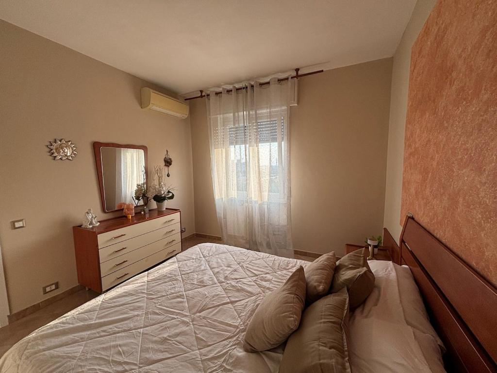 a bedroom with a bed and a dresser and a mirror at Modern Apartment - MIND District, Fiera Milano Rho in Baranzate