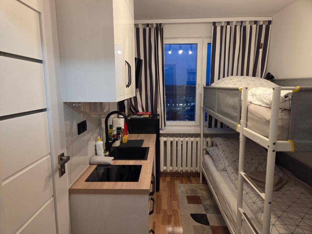 a small room with a bunk bed and a sink at STUDIO dla 2 osób in Suwałki