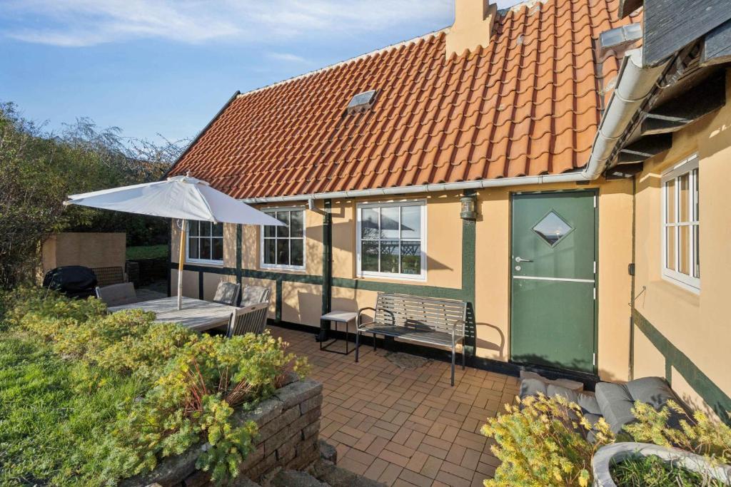 een terras met een groene deur en een parasol bij Family-Friendly Beachside Holiday Home in Arnager