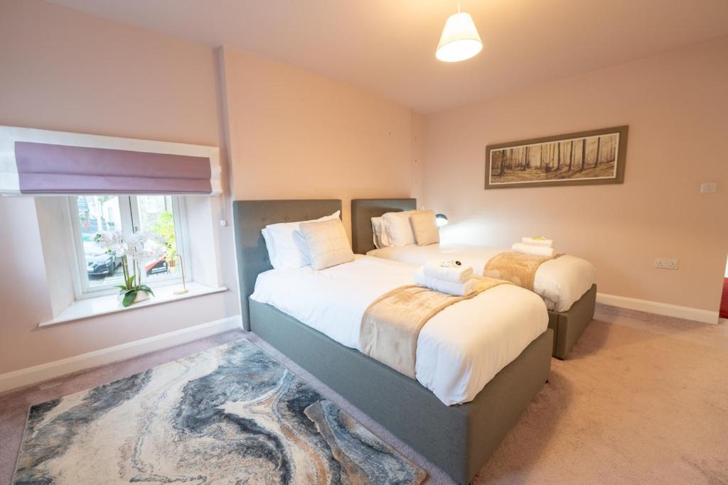 a bedroom with two beds and a window at Sunnyholme - New! Yorkshire Luxurious Cottage in Hawes