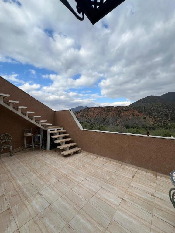 a patio with stairs on the side of a building at Dar louqman ourika in Asguine