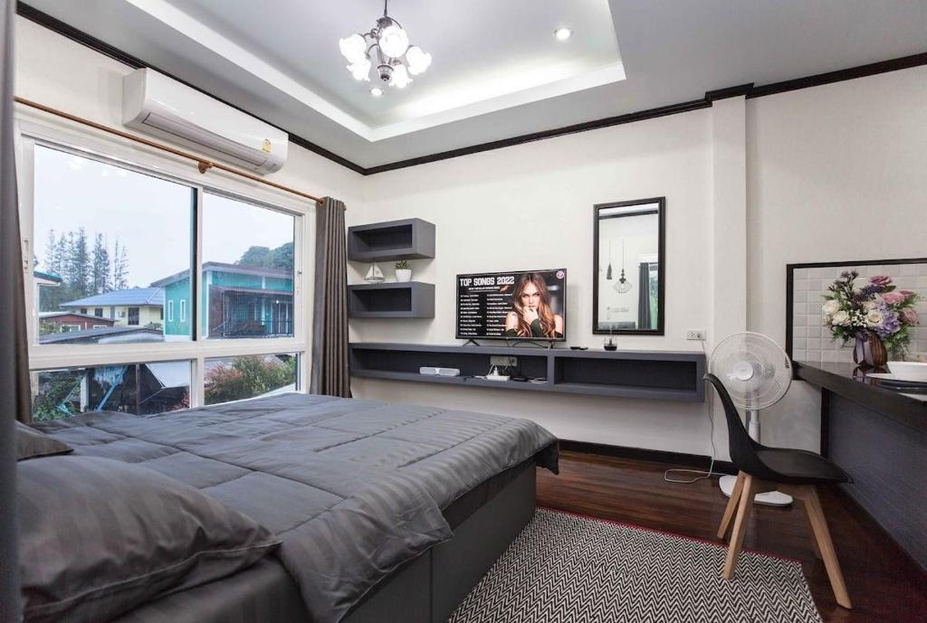 a bedroom with a bed and a desk and a window at Beautiful apartment in Ban Thalat Choeng Thale
