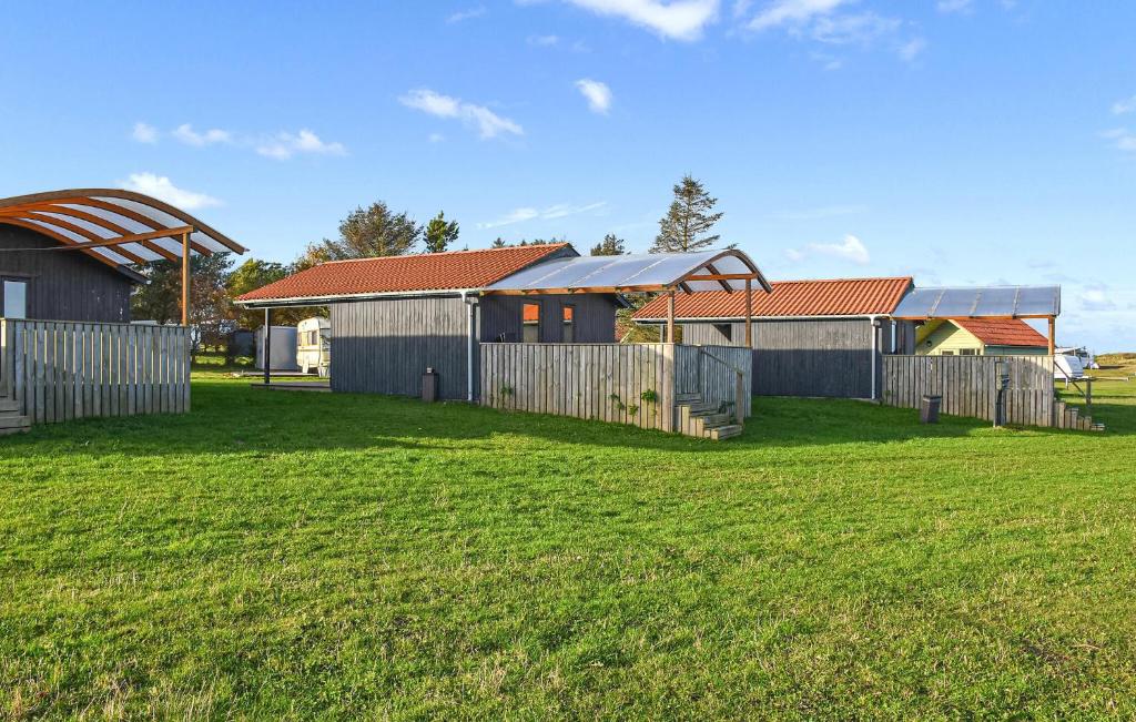 a group of buildings in a field with grass at Nice Home In Hanstholm With Private Swimming Pool, Can Be Inside Or Outside in Pugdal