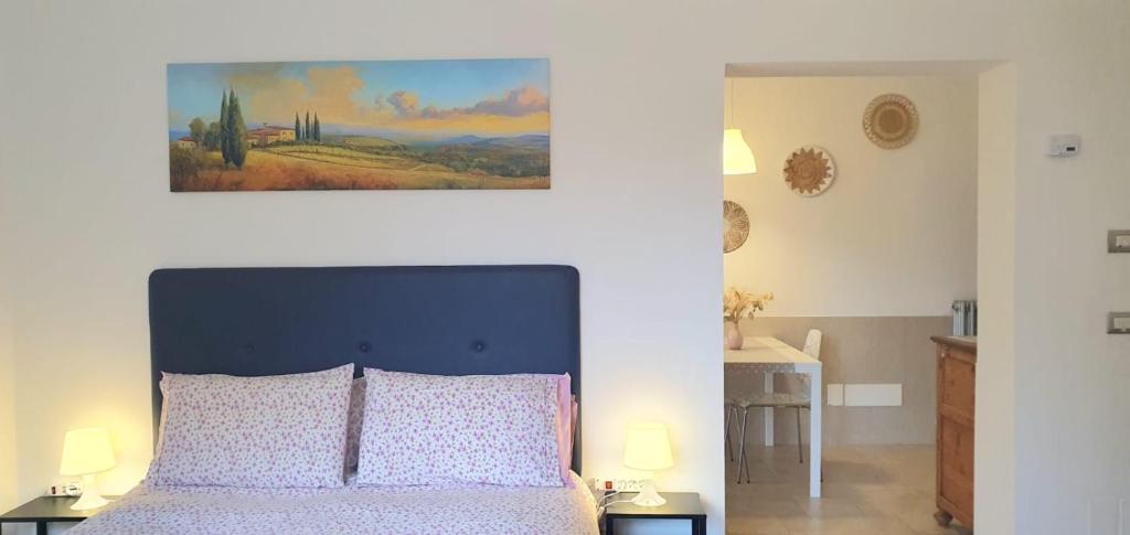 a bedroom with a bed with a painting on the wall at Maya Suite & Garden in Sarteano