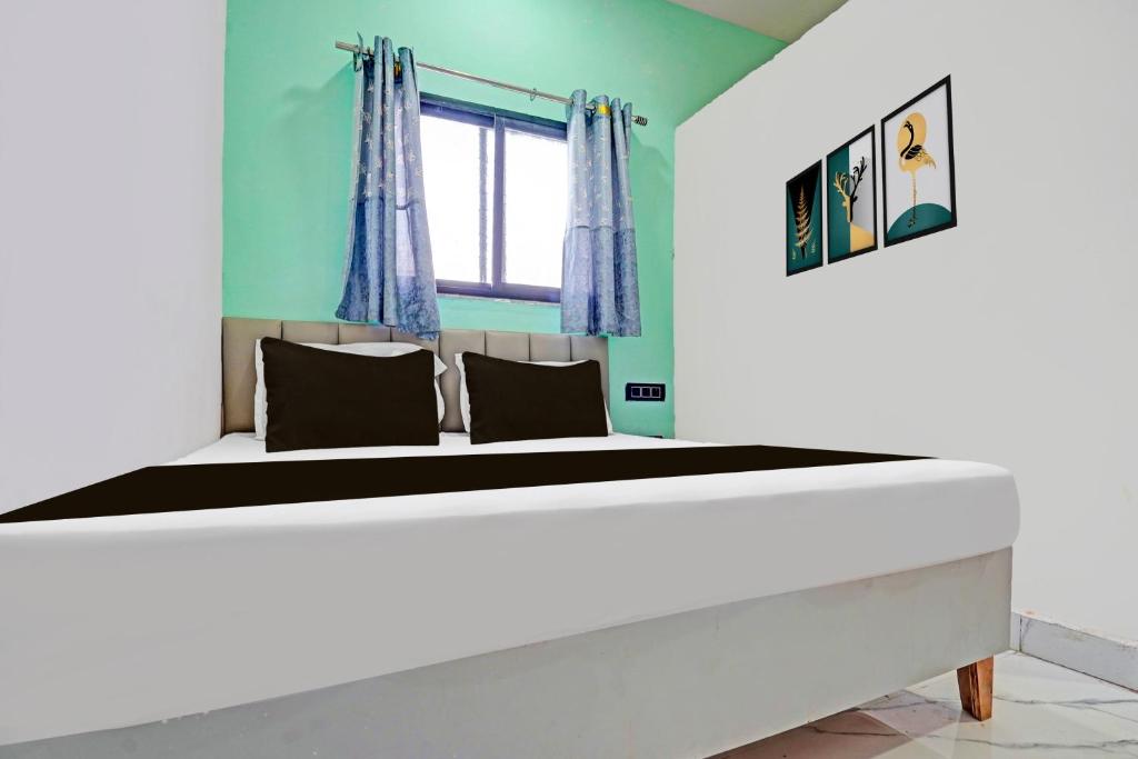 a bedroom with a large bed with blue walls at Hotel O Galaxy Stay in Chandrapur