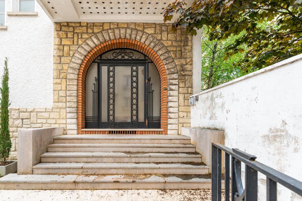 a black door on a brick house with stairs at Suite studio Darcy in Dijon