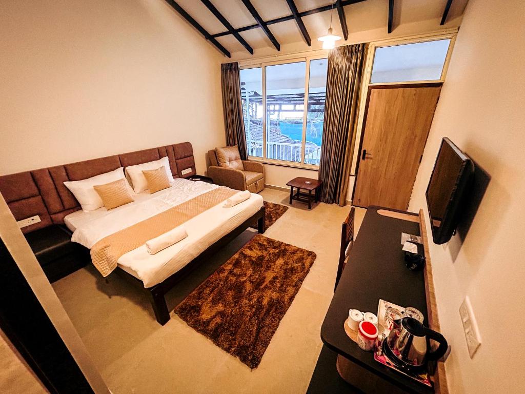 a small room with a bed and a television at Vista Mare in Vagator