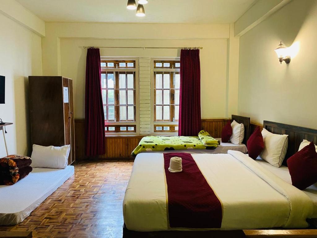 a hotel room with two beds and two windows at Changu Che Retreat ! Pelling in Pelling