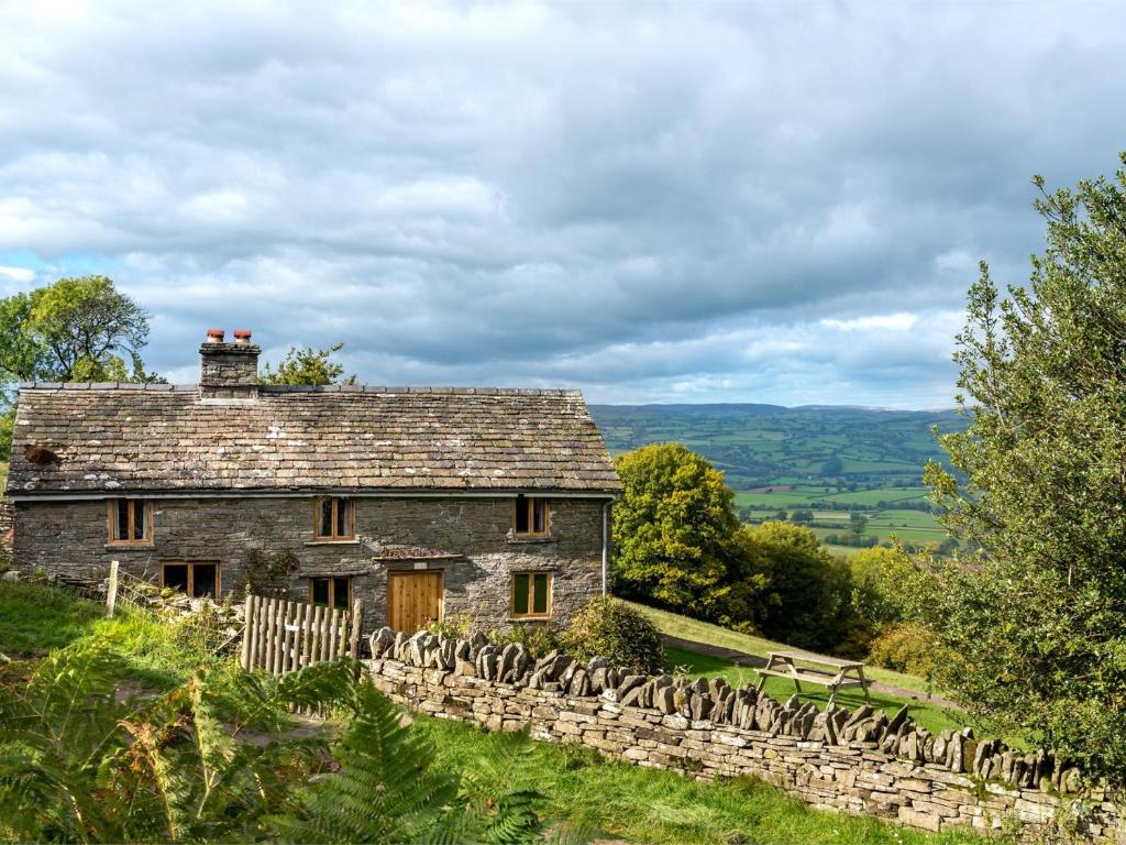 an old stone house on a hill with a fence at 3 Bed in Dorstone BN070 in Hardwicke