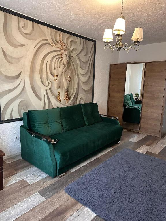 a green couch in a living room with a wall at Medusa Gold Studio in Târgu-Mureş