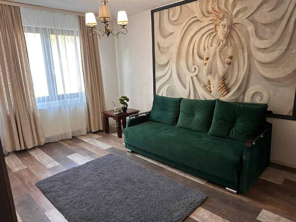 un soggiorno con divano verde di fronte a un muro di Medusa Gold Studio a Târgu-Mureş