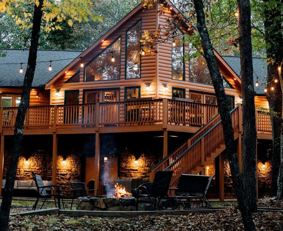 une grande cabane en rondins avec une terrasse et une cheminée dans l'établissement Fantastic Cabin with Fire Pit, Hot-tub and Fireplace in Sautee Nacoochee, Georgia, à Aerial