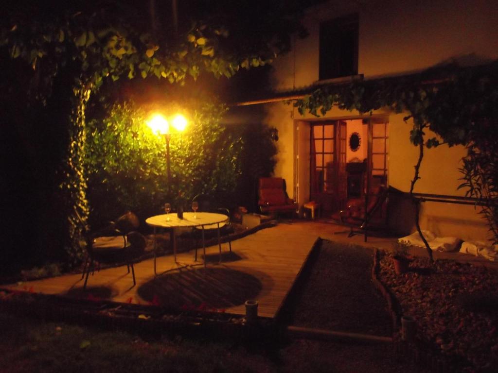 - un patio la nuit avec une table et une lumière dans l'établissement 43 Rue des Quarts, à Ménesplet