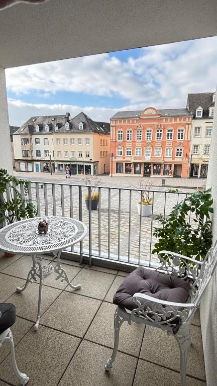 a balcony with a table and a chair and a table at Full City Apartment in Bitburg