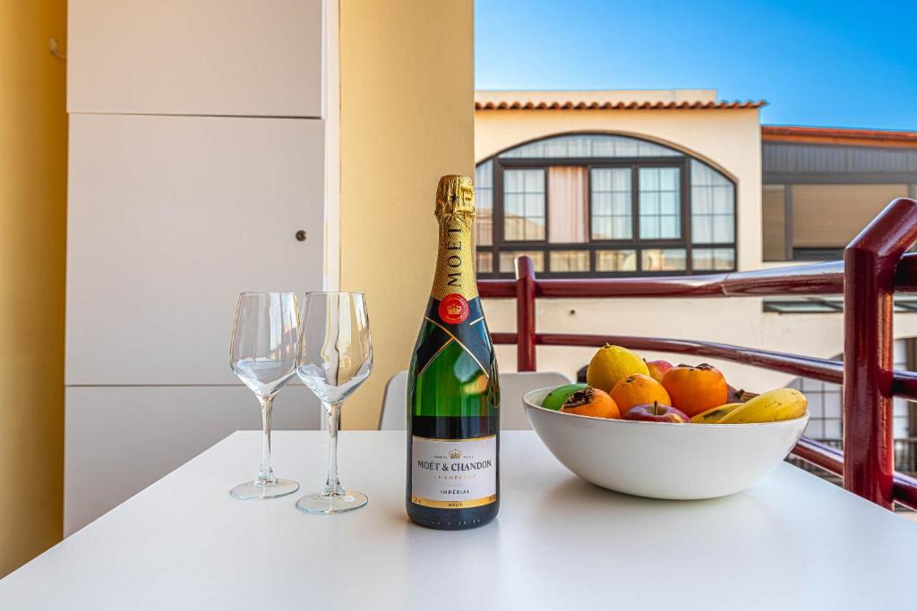 a bottle of champagne and a bowl of fruit on a table at Apartment in Los Cristianos WIFI in Arona