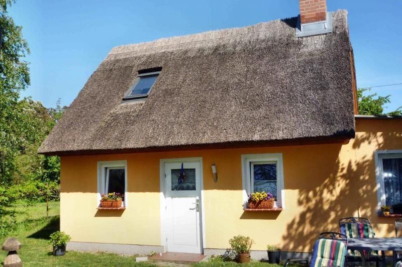 a yellow house with a thatched roof and two windows at Freistehendes Ferienhaus In Ruhiger Lage in Rubitz