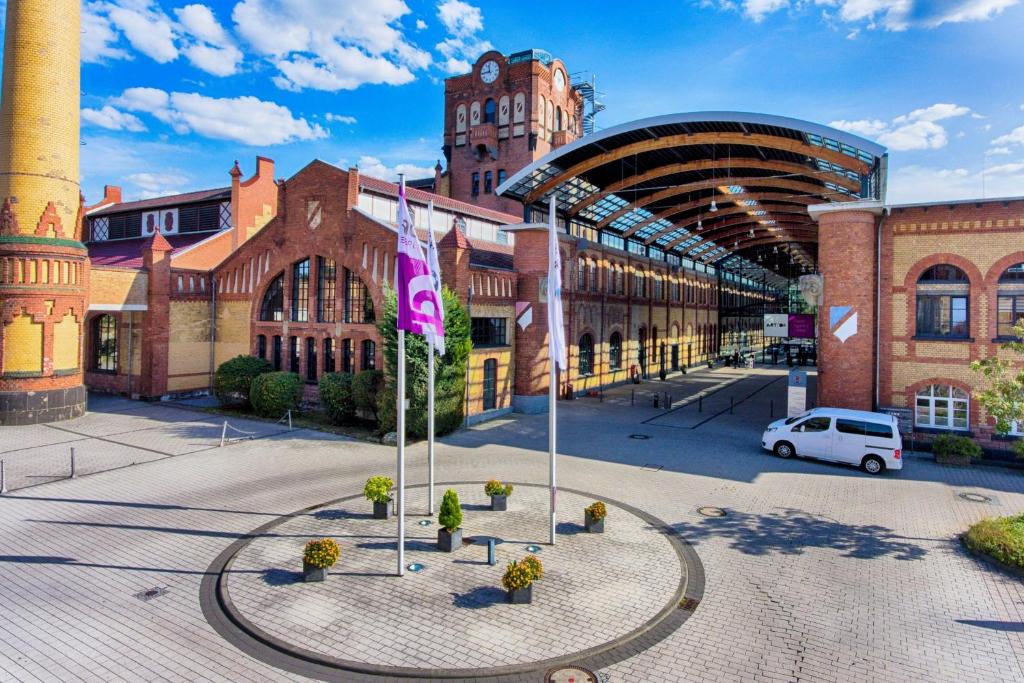 a building with a clock tower and a white van in front at Four Points by Sheraton Offenbach Plaza in Offenbach