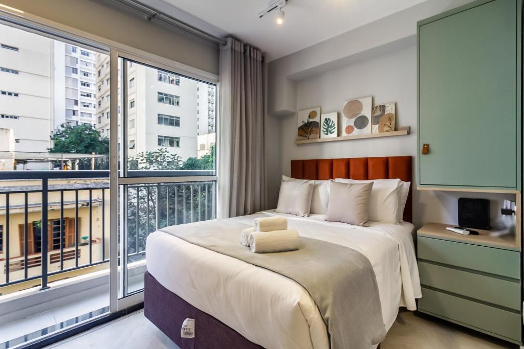 a bedroom with a large bed and a balcony at 360 Ascent Paulista in São Paulo