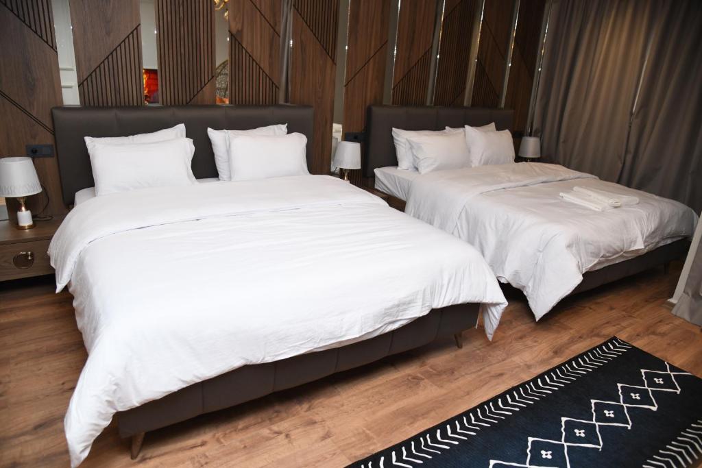 two beds in a room with white blankets and pillows at Suite Bahiya 11 in Fès