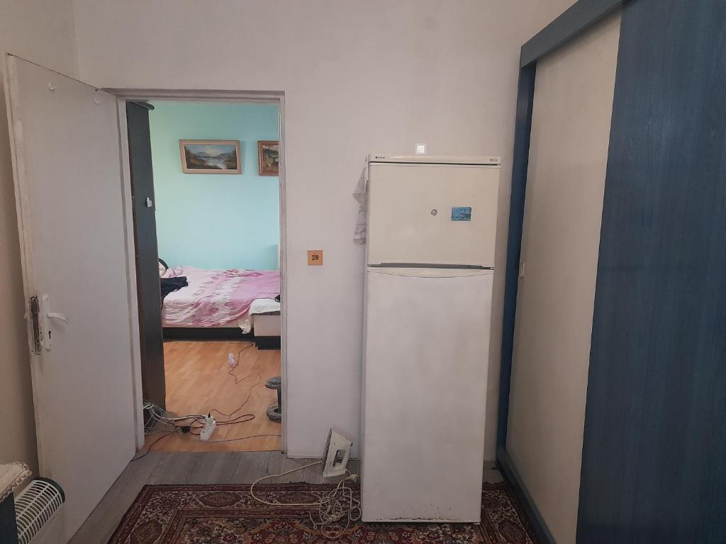 a white refrigerator in a room with a bedroom at Setra in Varna City