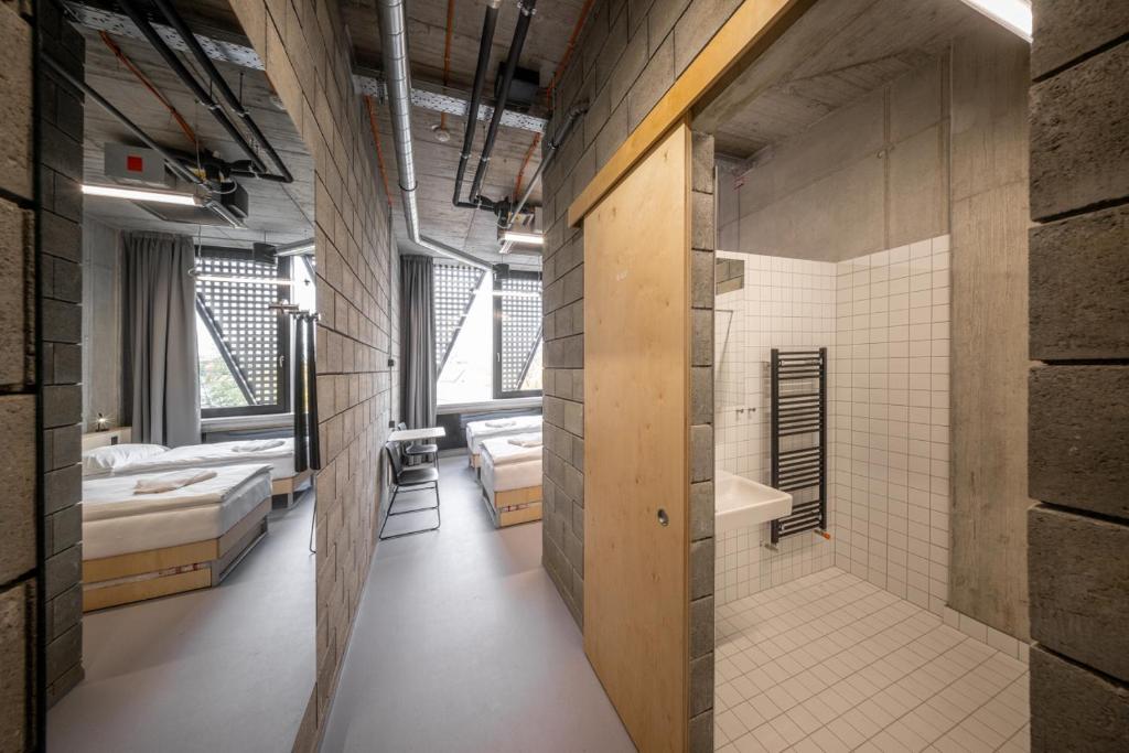 a large room with two beds and a bathroom at Hotel Aréna in Jihlava