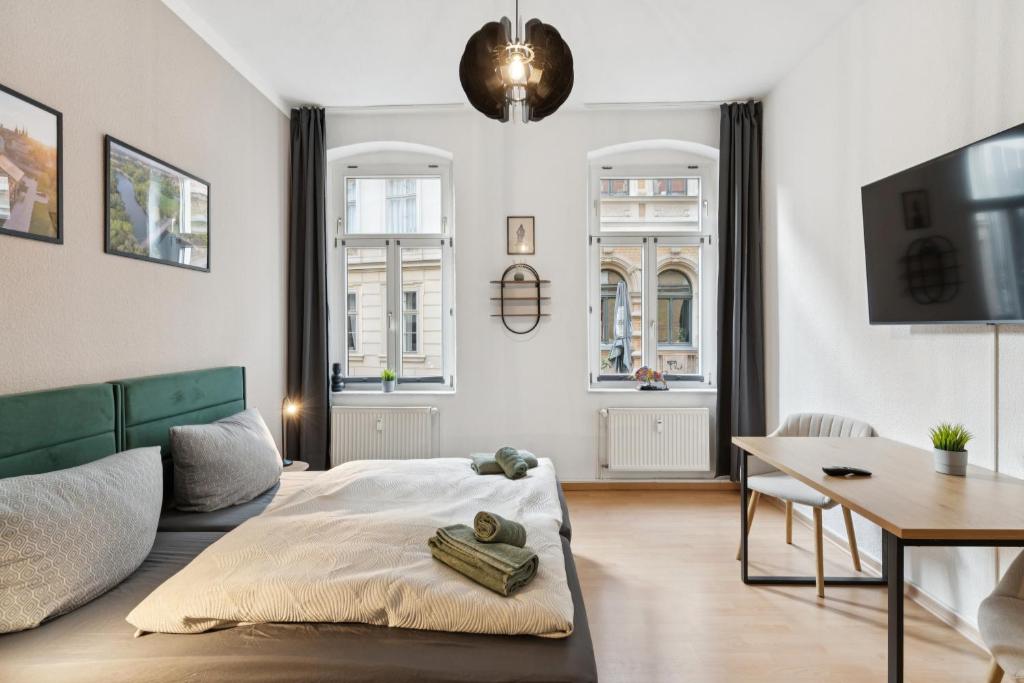 a living room with a bed and a table at Larooms KU11 - Zentrales & charmantes Altbauapartment - All inclusiv! in Halle Saale in Halle an der Saale