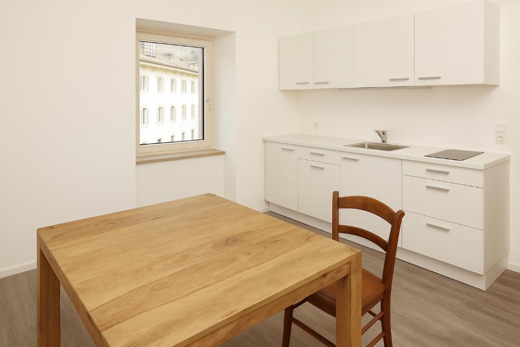 cocina con mesa de madera y silla de madera en HEIMAT - comfy Apartment, en Silandro