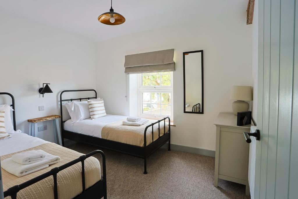 ein Schlafzimmer mit zwei Betten und einem Fenster in der Unterkunft Pentwyn Cottage, Bwlch Brecon in Bwlch