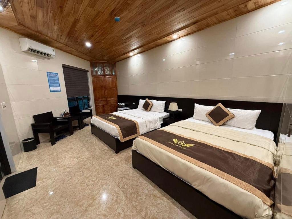 a hotel room with two beds and a desk at Khách sạn Giang Sơn Bắc Hà Lào Cai in Bắc Hà